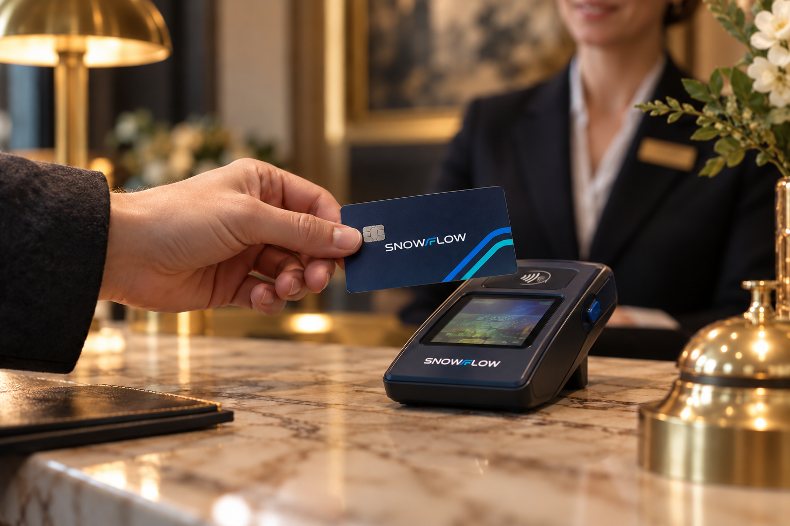 A guest using the navy Snowflow card with its silver chip and paired blue-turquoise routes at a matching branded hotel terminal